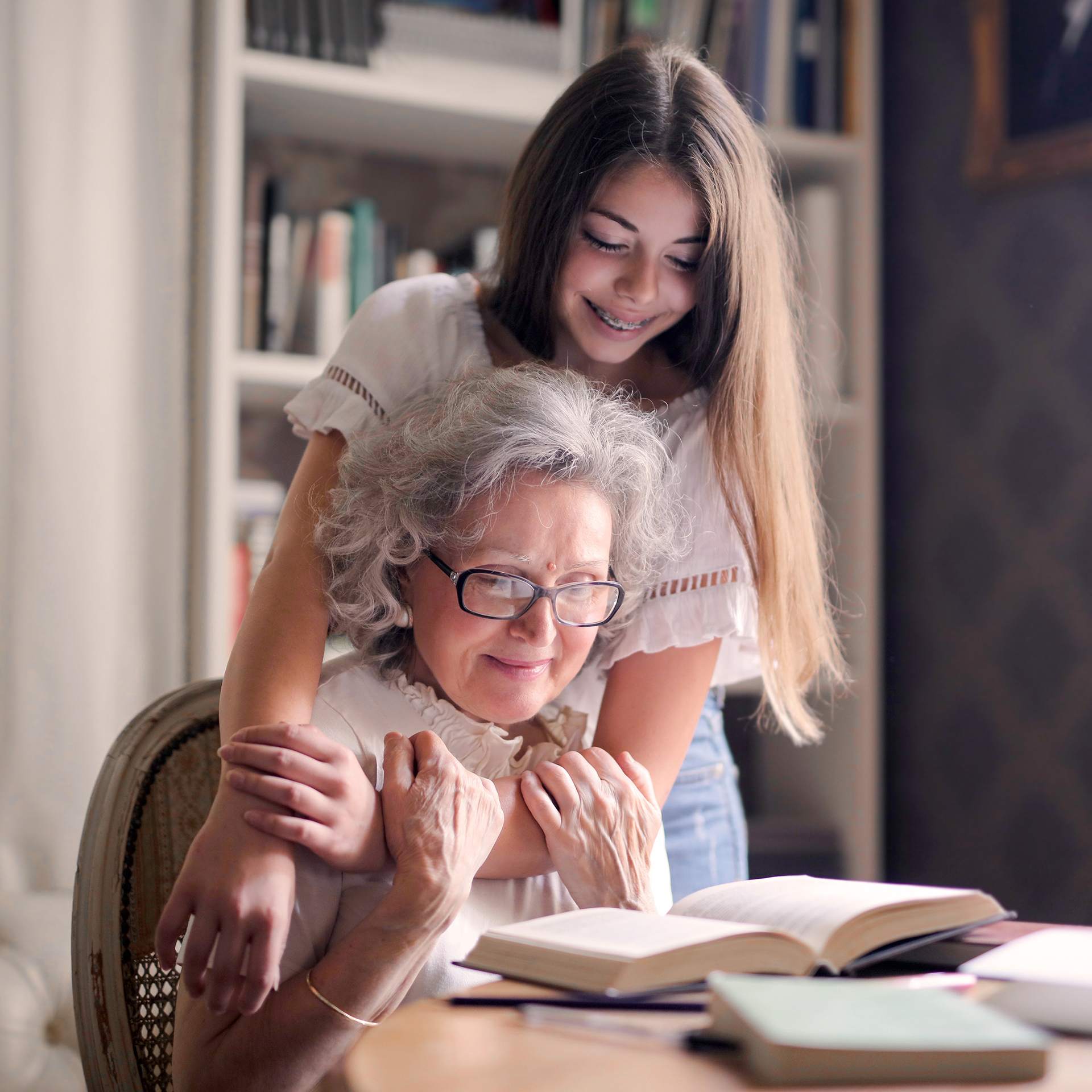 A granddaughter and grandmother reading a book